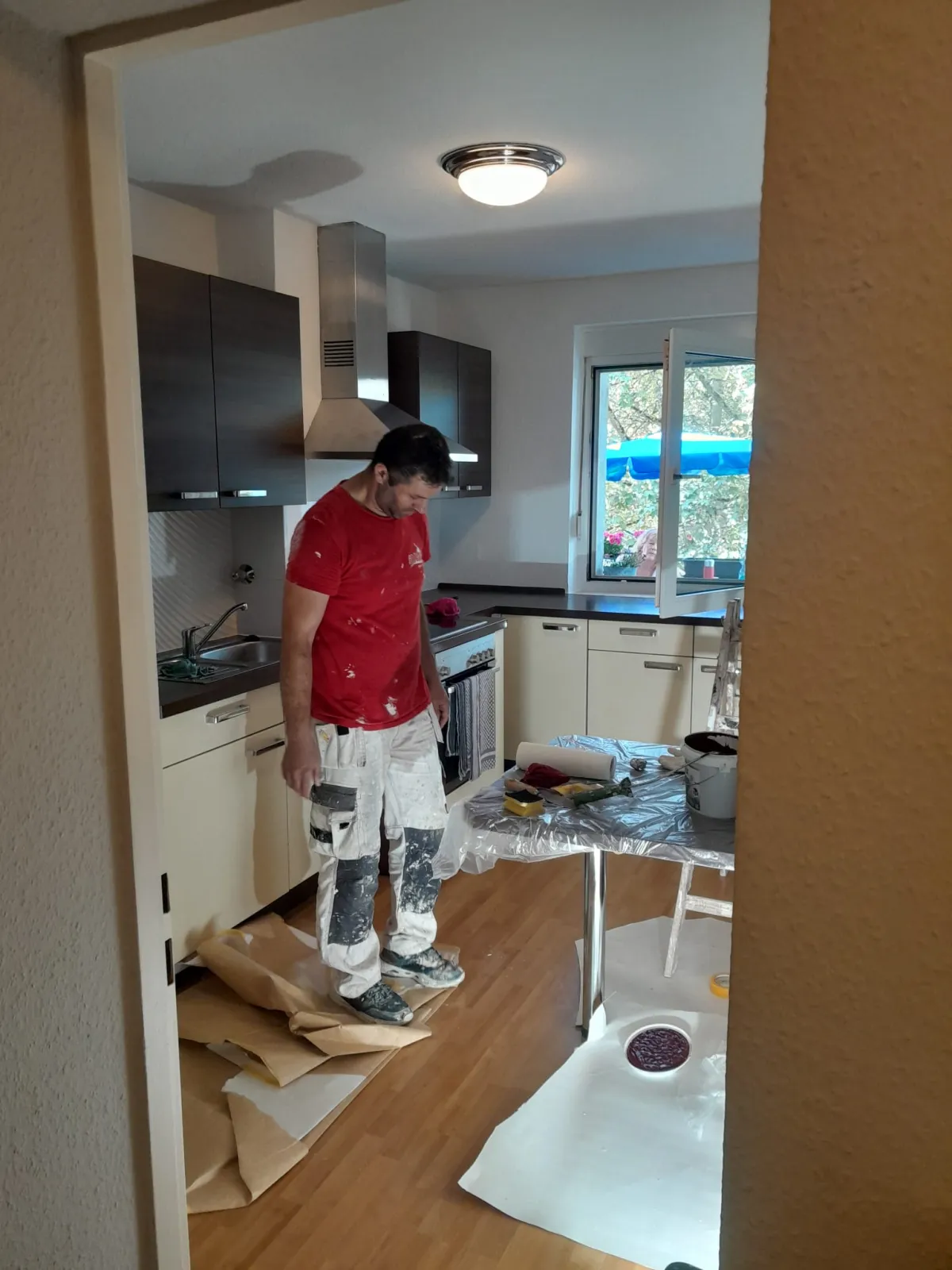 Maler im roten Andymen-Shirt bei Malerarbeiten in K&uuml;che Erlensee