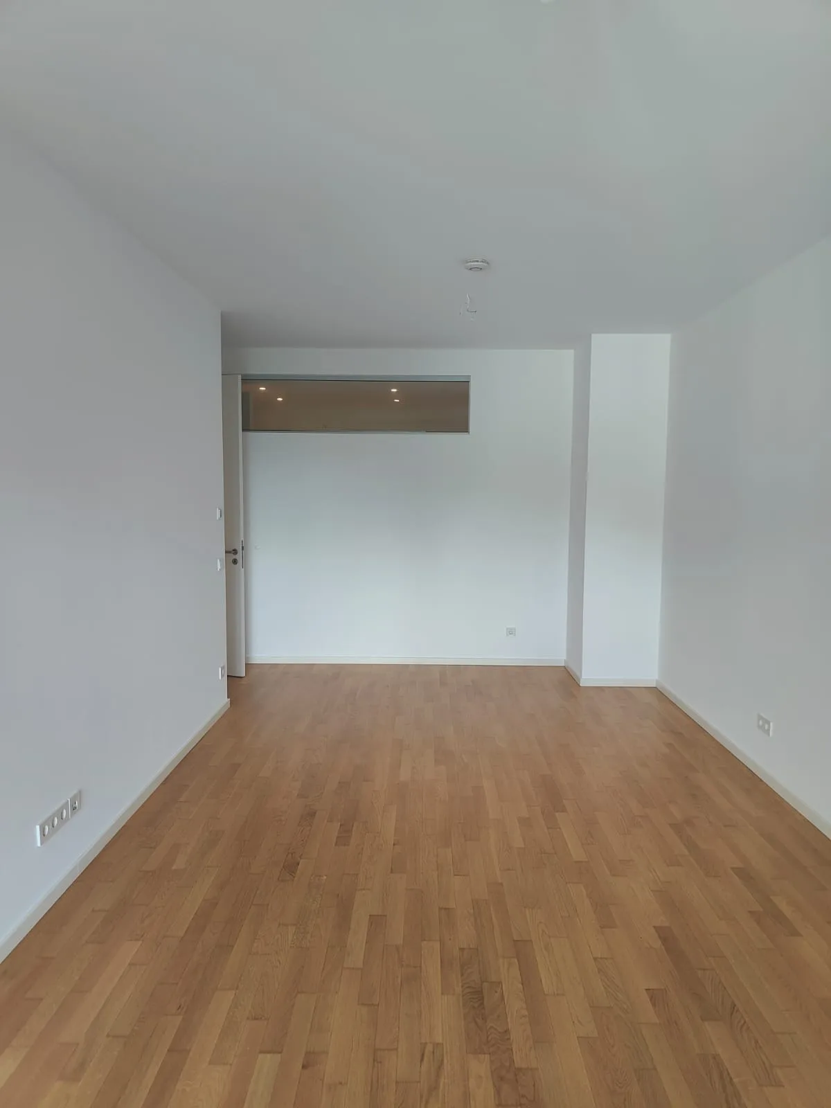 Zweites Zimmer fertig gestrichen mit Holzboden und Glasfenster zum Bad