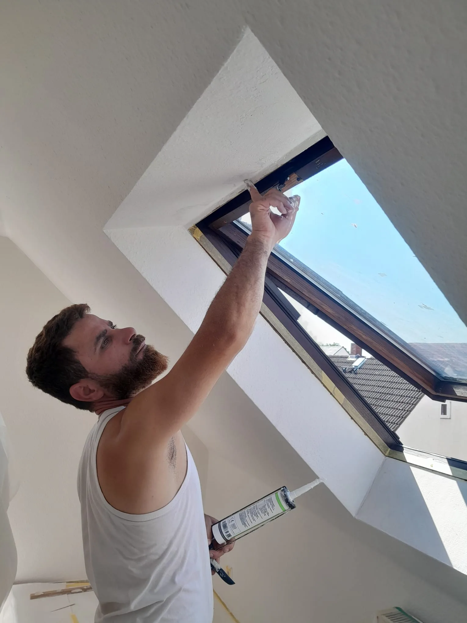 Andymen-Maler versiegelt Dachfl&auml;chenfenster in Dachgeschosswohnung