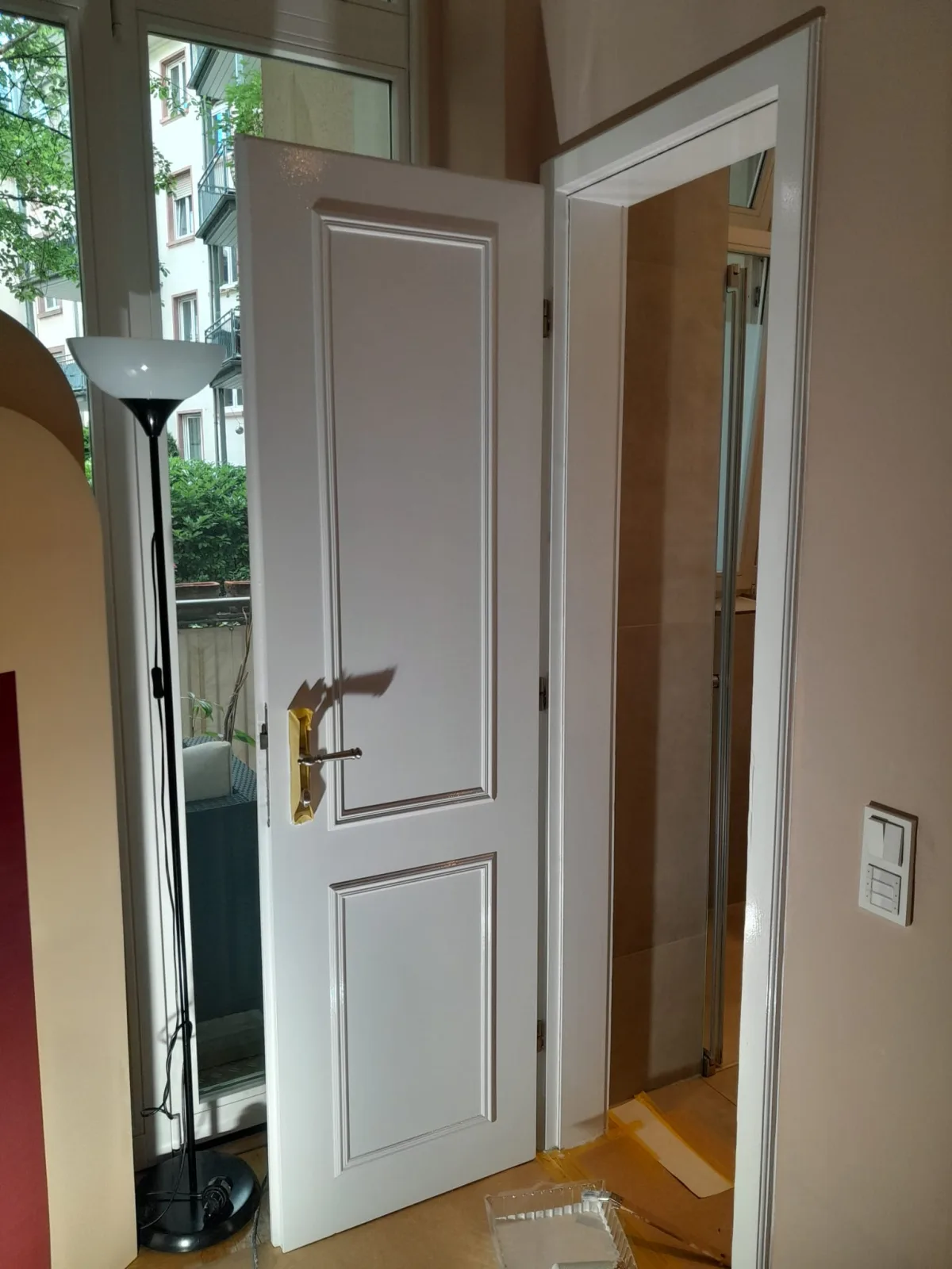 Frisch lackierte wei&szlig;e Zimmert&uuml;r mit goldenen Beschl&auml;gen &mdash; Altbau Frankfurt-Nordend, Ergebnis Lackierarbeiten