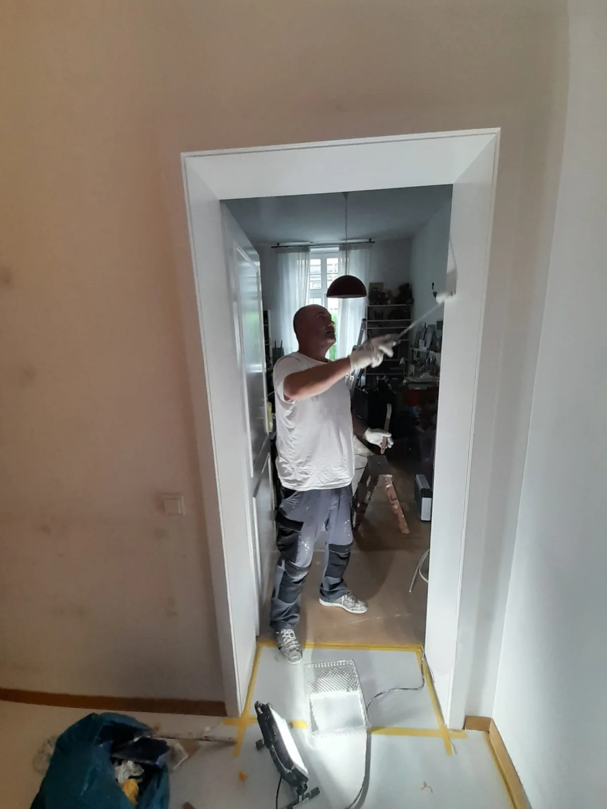 Maler rollt T&uuml;rzarge und Sturz wei&szlig; &mdash; Boden abgeklebt, Altbau Frankfurt-Nordend