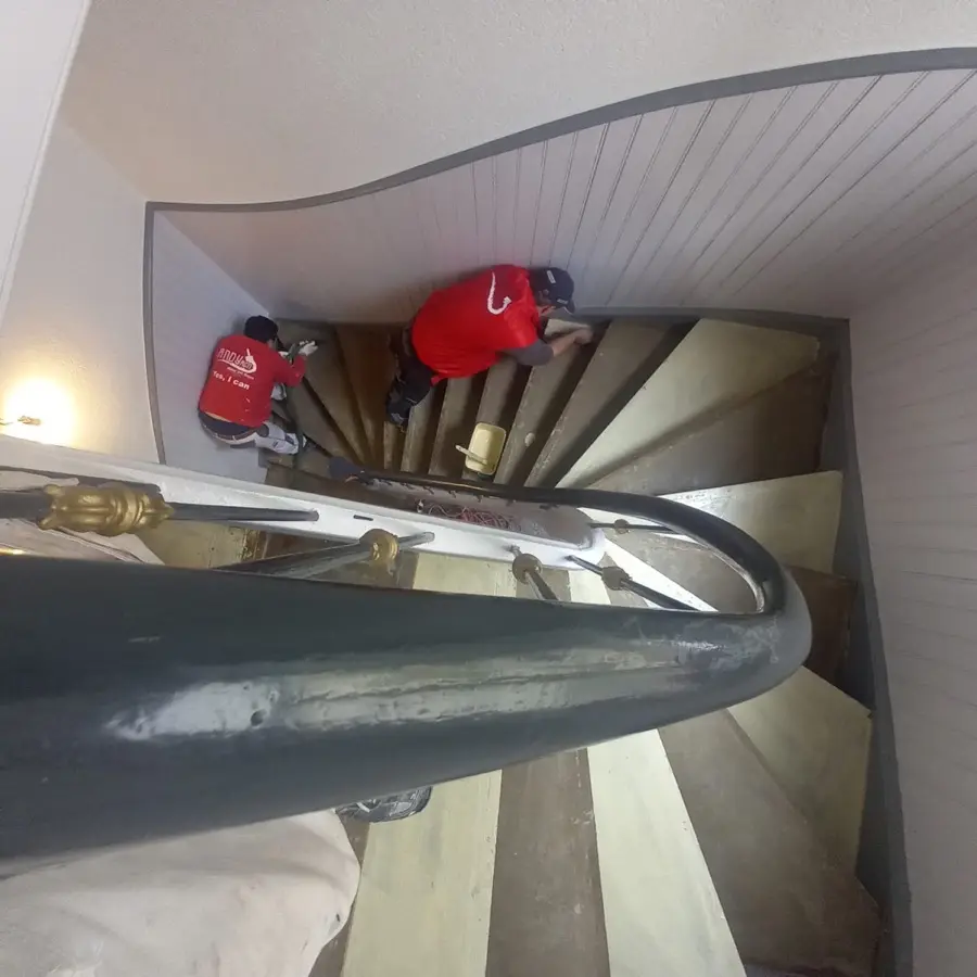 Treppenhausrenovierung Bad Nauheim &mdash; Andymen Team bei der Arbeit, rote Jacken, Wendeltreppe