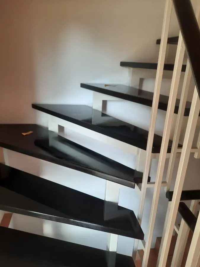 Treppenhaus nach Renovierung &mdash; schwarze Holztreppe, wei&szlig;e W&auml;nde, Andymen Frankfurt