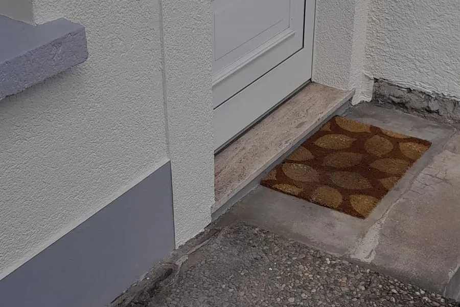 Neubau Fassade fertig — frischer Eingangsbereich weiß/grau gestrichen, Andymen Maler