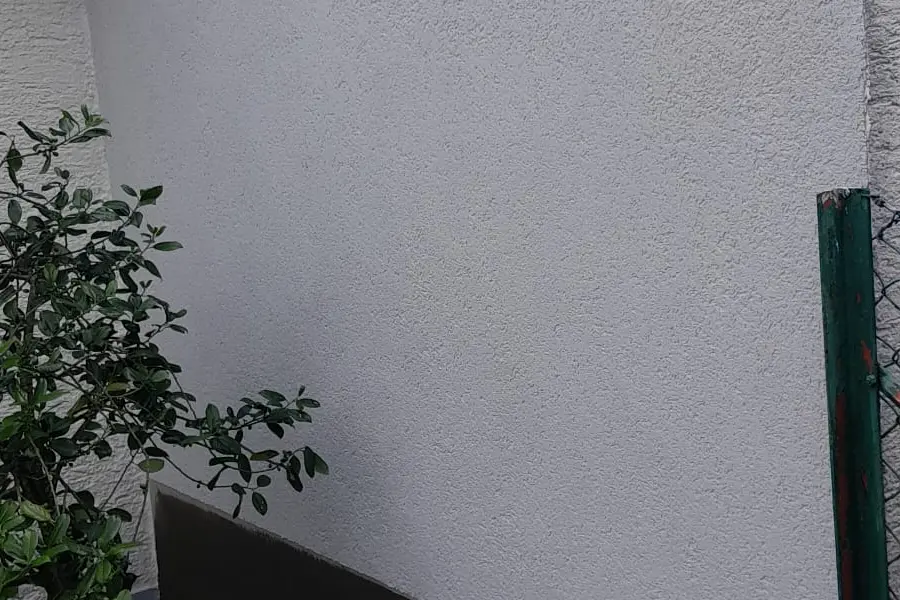 Fassadenanstrich für Hausverwaltungen — weiße Fassade mit grauem Sockel, Andymen Maler mit Stern